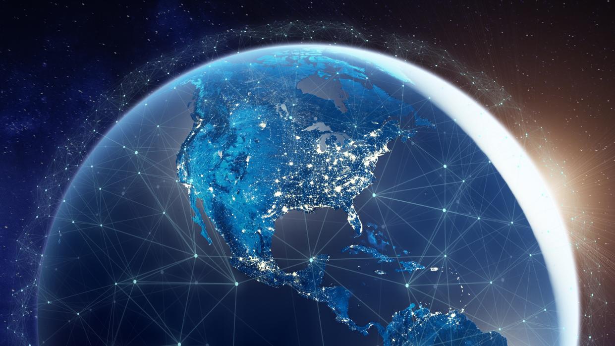  An illustration of Earth with lots of lines all around, representing signals sent between phone towers and such. 