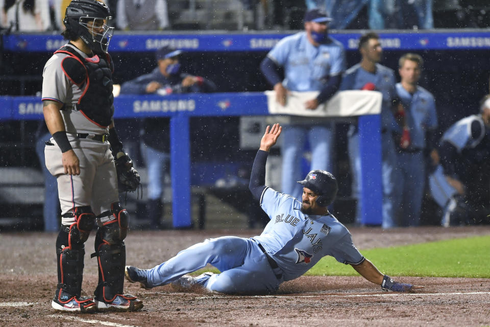 Toronto Blue Jays' Marcus Semien (10) scores against the Miami Marlins on a two-run triple by Bo Bichette during the ninth inning of a baseball game in Buffalo, N.Y., Wednesday, June 2, 2021. The Blue Jays won 6-5. (AP Photo/Adrian Kraus)