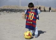 Five year-old Murtaza Ahmadi, an Afghan Lionel Messi fan, shows a shirt signed by Barcelona star Lionel Messi, before he plays football at the open area in Kabul, Afghanistan February 26, 2016. REUTERS/Omar Sobhani