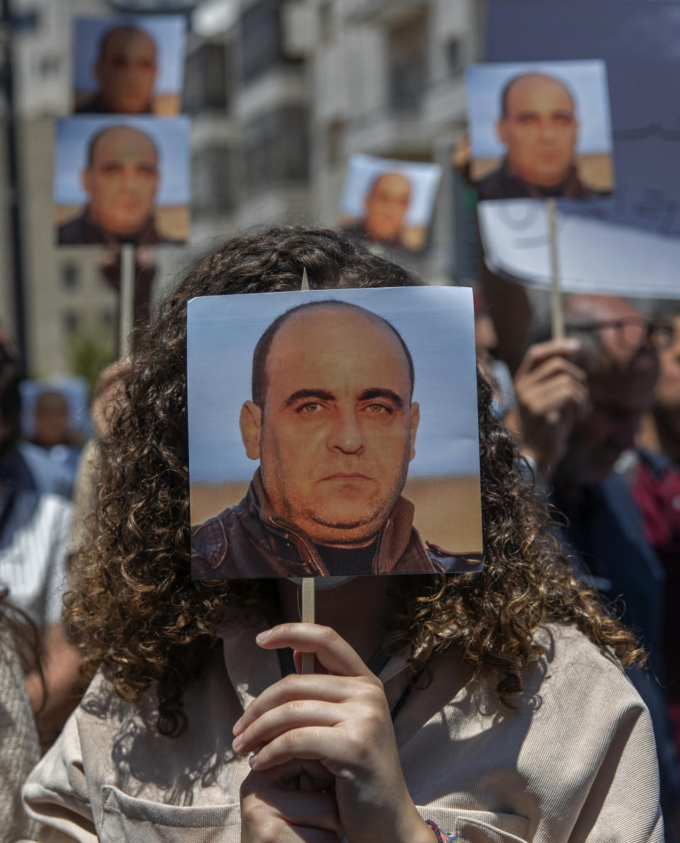 Angry demonstrators carry pictures of Nizar Banat, an outspoken critic of the Palestinian Authority, and chant anti-PA slogans during a rally protesting his death, in the West Bank city of Ramallah, Thursday, June 24, 2021. Banat who was a candidate in parliamentary elections called off earlier this year died after Palestinian security forces arrested him and beat him with batons on Thursday, his family said. (AP Photo/Nasser Nasser)