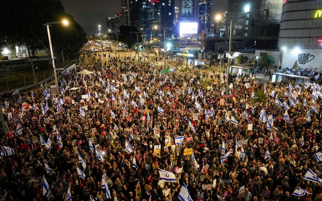 People protest against Israeli Prime Minister Benjamin Netanyahu's government and call for the release of hostages held in the Gaza Strip by the Hamas militant group in Tel Aviv, Israel, Saturday, April 13, 2024. (AP Photo/Ohad Zwigenberg)
