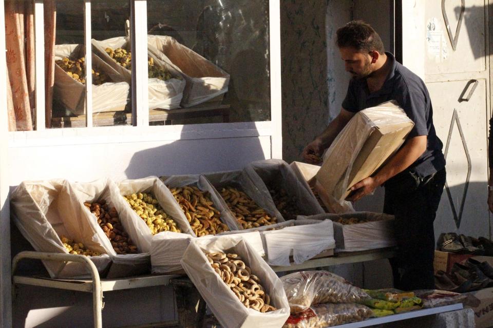 A man arranges sweets into boxes in a market ahead of the upcoming Muslim Eid al-Adha holiday in Manbej, in Aleppo countryside October 12, 2013. Picture taken October 12, 2013. REUTERS/Nour Fourat (SYRIA - Tags: RELIGION FOOD)