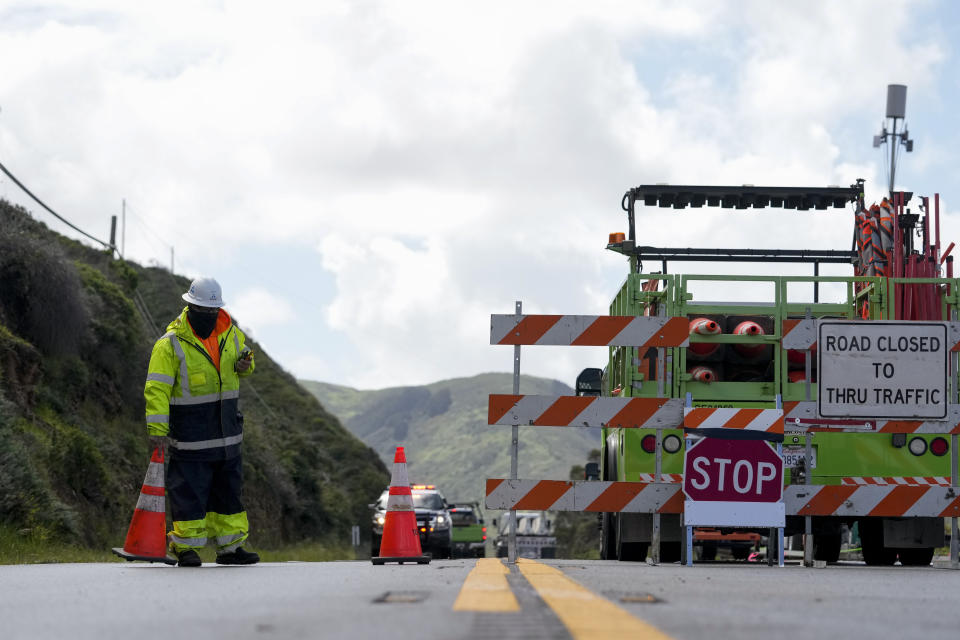 A construction worker places a traffic cone at a road closure on Highway 1 near Big Sur, Calif., Thursday, April 4, 2024. The closure was caused by a break in the southbound lane of Highway 1 at Rocky Creek Bridge. (AP Photo/Godofredo A. Vásquez)
