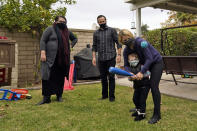 Heather Schmidt, left, and her husband Nicholas Philbrook watch as their son Andrew, 4, plays with their daughter Alexis at home, Wednesday, Nov. 18, 2020, in Camarillo, Calif. Philbrook and his wife have been trying to convince court officials that he should be excused from jury duty because her father, a cancer survivor with diabetes, lives with them. But court officials told him that is not a valid reason and he must appear in court in early December. (AP Photo/Marcio Jose Sanchez)