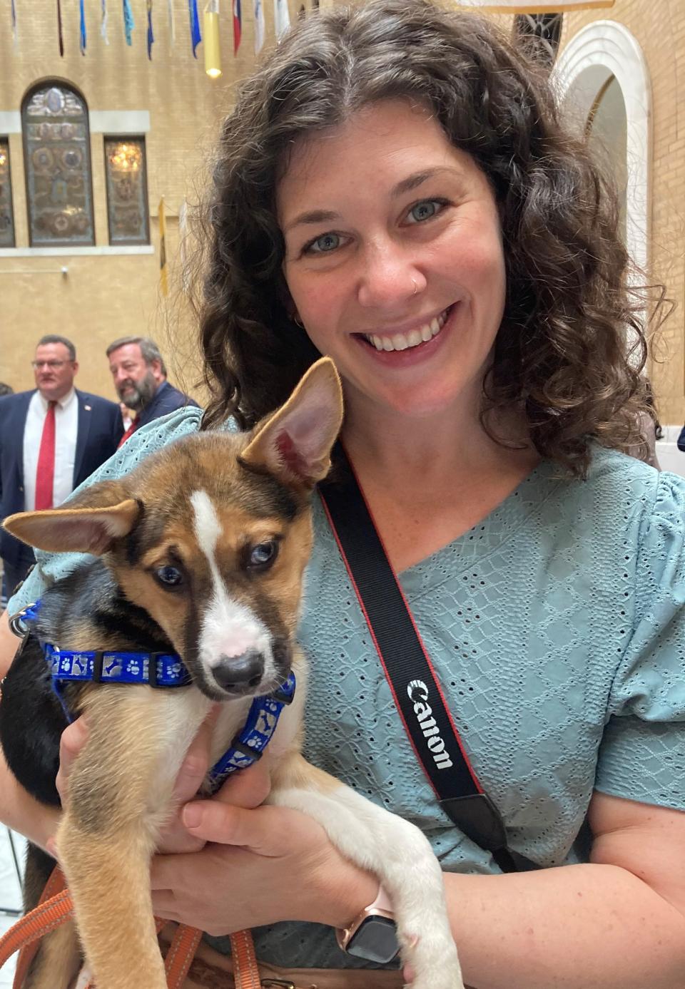 Luna, tired after a morning of greeting strangers Tuesday at Animal Advocacy Day at the State House, takes a break with animal advocate Diana Lee of the MSPCA.