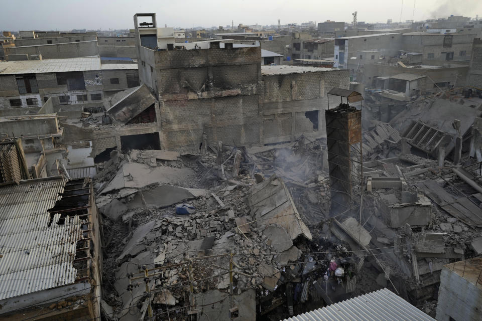 Smoke rises from the site of a fire in Karachi, Pakistan, Thursday, April 13, 2023. A massive fire broke out in a garment factory in the southern Pakistan port city of Karachi. The cause of the blaze, which ripped through the factory Wednesday night and eventually caused it to collapse, was not immediately known, rescue officials and police said. (AP Photo/Fareed Khan)