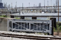 A flood gate and seawall, that will be increased in size, is shown near a refinery Thursday, July 26, 2018, in Port Arthur, Texas. The oil industry wants the government to help protect some of its facilities on the Texas Gulf Coast against the effects of global warming. One proposal involves building a nearly 60-mile “spine” of flood barriers to shield refineries and chemical plants. Many Republicans argue that such projects should be a national priority. But others question whether taxpayers should have to protect refineries in a state where top politicians still dispute whether climate change is real. (AP Photo/David J. Phillip)