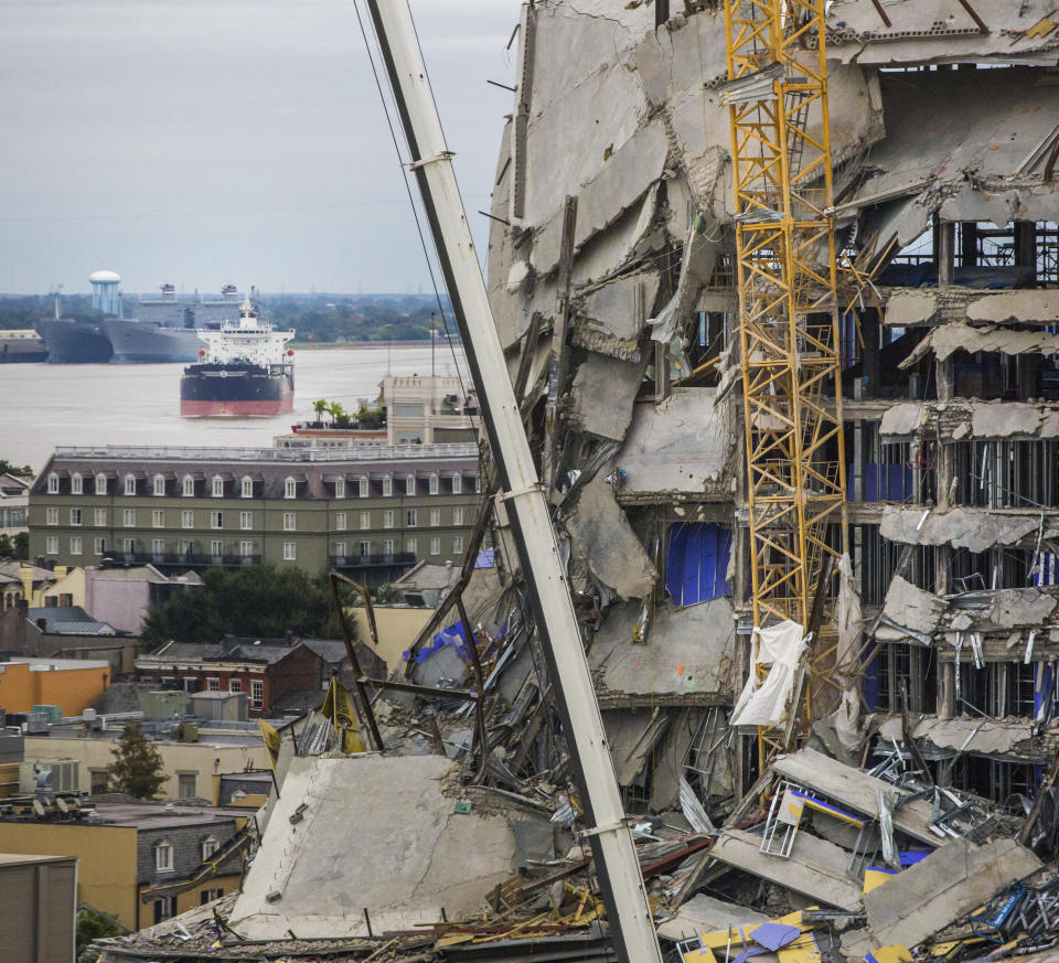 A ship floats on the Mississippi River by the Hard Rock Hotel construction site in New Orleans, Friday, Oct. 18, 2019. The Hard Rock Hotel partially collapsed last week. (Sophia Germer/The Advocate via AP)