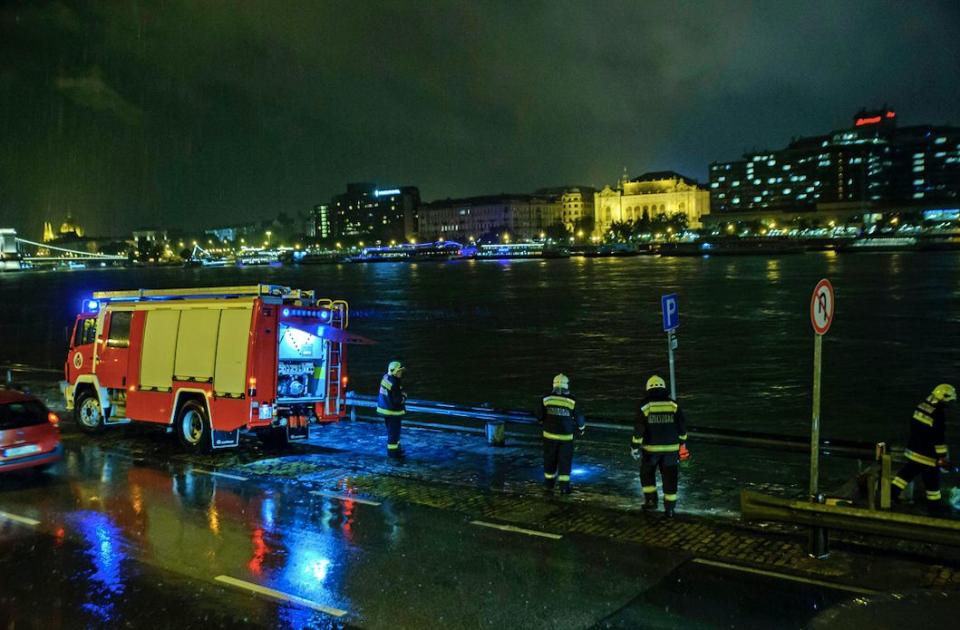 Rescuers search for victims on the river bank after a boat sank on the Danube River in Budapest (AP)