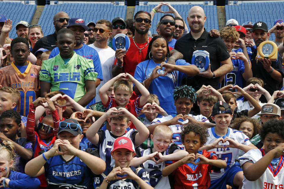 Buffalo Bills defensive back Damar Hamlin holds a AED, (Automatic Electronic Defibrillator) to help resuscitate heart attack victims, and poses with fans following the announcement of the first program of his Chasing M's Foundation, the Chasing M's Foundation CPR Tour, Saturday, June 3, 2023, in Orchard Park, N.Y. (AP Photo/Jeffrey T. Barnes)