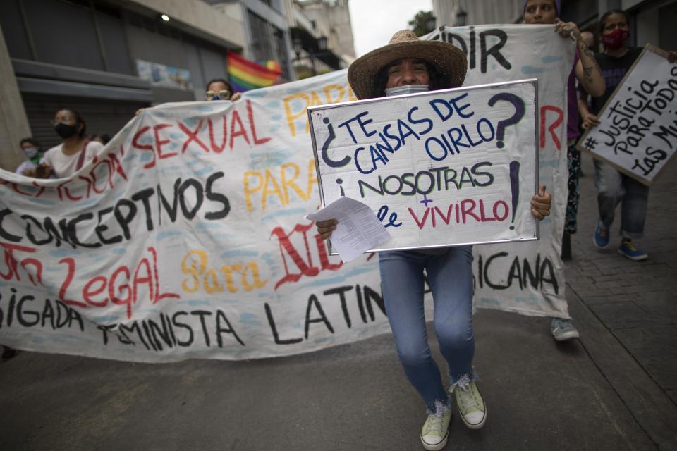 Women from the feminist group "Tinta Violeta" march during a protest marking International Women's Day and demanding justice for women who have been victims of violence in Caracas, Venezuela, Monday, March 8, 2021. (AP Photo/Ariana Cubillos)