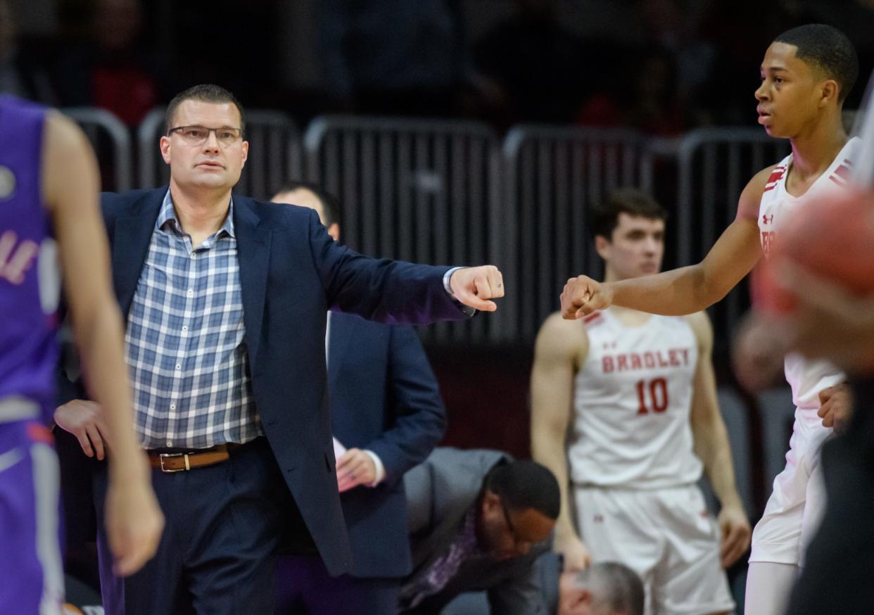 Bradley coach Brian Wardle, left, fist bumps Jayson Kent as the Braves battle Evansville in the first half this week at Carver Arena. BU travels to face rival Illinois State at 7 p.m. Sunday in Normal.