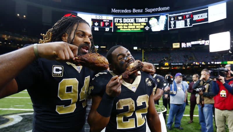 New Orleans Saints defensive end Cameron Jordan (94) and running back Mark Ingram (22) eat turkey drumsticks after their Thanksgiving night game against the Atlanta Falcons in New Orleans, Thursday, Nov. 22, 2018. The Saints won 31-17. 