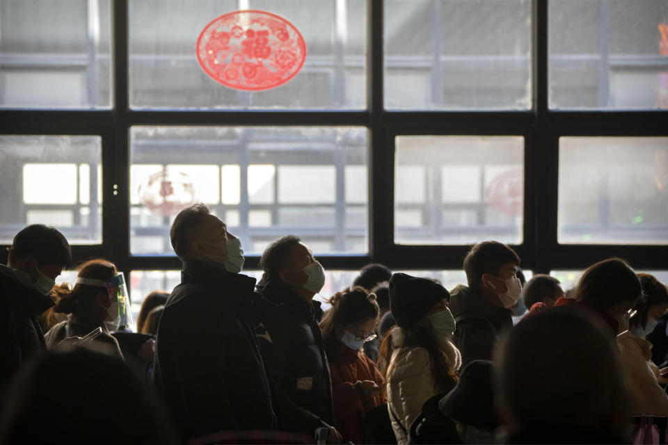 Travelers stand in line to board a train at Beijing West Railway Station in Beijing, Wednesday, Jan. 18, 2023. China in December lifted its strict "zero-COVID" policy, letting loose a wave of pent-up travel desire, particularly around China's most important time for family gatherings, referred to in China as the Spring Festival, that may be the only time in the year when urban workers return to their hometowns. (AP Photo/Mark Schiefelbein)