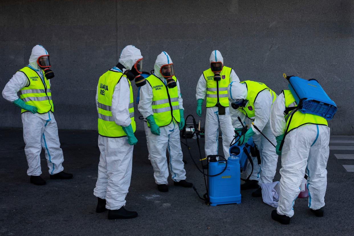 Spanish Royal guard soldiers disinfect a hospital to prevent the spread of the new coronavirus in Madrid, Spain, on Sunday, March 29, 2020. Spain and Italy demanded more European help as they fight still-surging coronavirus infections amid the continent's worst crisis since World War II.