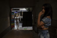 A resident of the squat Casa Nem waits at the entrance for a delivery of donated furniture, in Rio de Janeiro, Brazil, Wednesday, July 8, 2020. The six-floor building is home to members of the LGBTQ community riding out the pandemic behind closed doors. (AP Photo/Silvia Izquierdo)