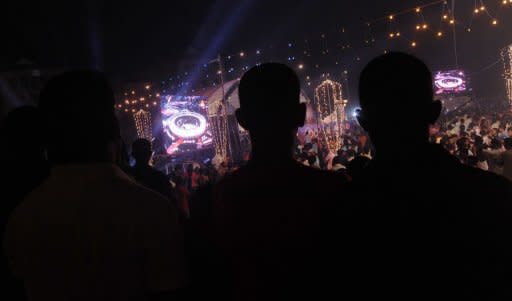 Sri Lankans watch the live television broadcast of the London Olympics opening ceremony, at the sea front Galle Face promenade in the capital Colombo on July 28, 2012