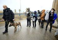 A security officer walks with a dog as journalists gather near the building of Lebanese Press Syndicate where former Nissan chairman Carlos Ghosn is expected to hold a news conference in Beirut