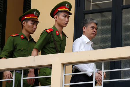 Former Petro Vietnam (PVN) chairman Nguyen Xuan Son (R) is escorted by police as he leaves the court after the verdict session in Hanoi, Vietnam September 29, 2017. REUTERS/Kham