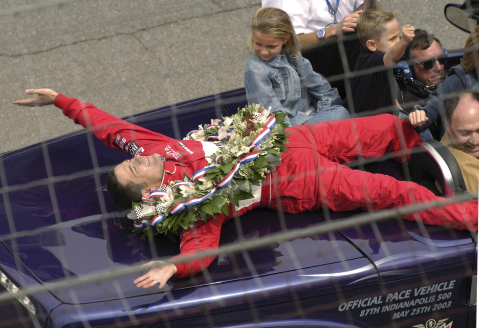 FILE - Gil de Ferran, of Brazil, winner of the Indianapolis 500, lies back on the pace car as he takes a post-victory lap of the Indianapolis Motor Speedway on Sunday, May 25, 2003, in Indianapolis. De Ferran's children Anna Elizabeth and Luke joined him for the ride. De Ferran, holder of the closed-course land speed record, died Friday, Dec. 29, 2023, while racing with his son at The Concourse Club in Florida, multiple former colleagues confirmed to The Associated Press. He was 56. (AP Photo/Doug McSchooler, File)