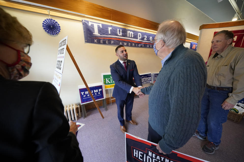 FILE - In this Thursday, Oct. 15, 2020 file photo, Slippery Rock, Pa., Republican Mayor Jondavid Longo, center, greets Donald Trump supporters Dale Filstrup, left, and her husband, Al, second right, of Pittsburgh, at the Butler County Republican Committee office in Slippery Rock, Pa. Trump won Butler County handily in November, evidence of his campaign to supercharge turnout in rural, conservative places as he cedes ground in the cities and suburbs. (AP Photo/Gene J. Puskar)