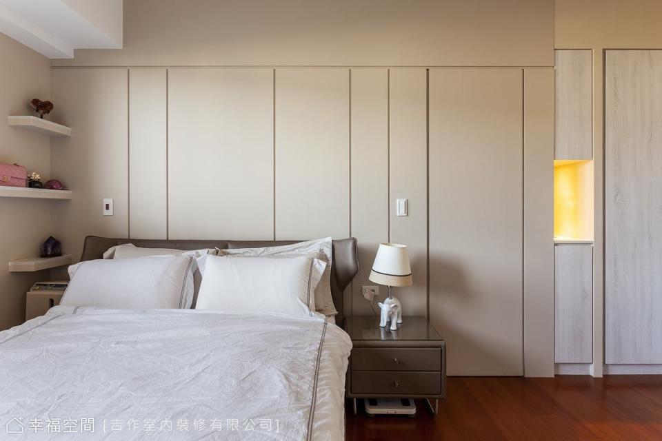 主臥房床頭牆面以線條分割出不一的幾何區塊，並將衛浴入口巧妙置入，保持視覺的一致性。