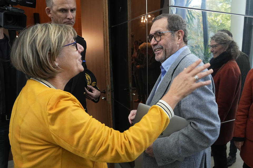 French physicist Alain Aspect is welcome by French Minister for High Education and Research Sylvie Retailleau, left, before a press conference, Tuesday, Oct. 4, 2022 in Palaiseau, outside Paris. Frenchman Alain Aspect, American John F. Clauser and Austrian Anton Zeilinger were cited by the Royal Swedish Academy of Sciences for discovering the way that unseen particles, such as photons or tiny bits of matter, can be linked, or "entangled," with each other even when they are separated by large distances.(AP Photo/Michel Euler)