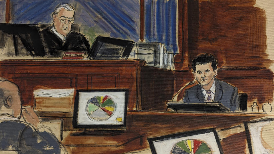 In this courtroom sketch, FTX founder Sam Bankman-Fried, right, testifies as Judge Lewis Kaplan, upper left, presides during Bankman-Fried's trial in Manhattan federal court, Tuesday, Oct. 31, 2023, in New York. A pie chart showing where all the customer funds were spent is displayed on monitors. (Elizabeth Williams via AP)