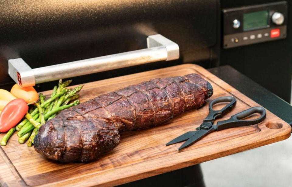 A pair of premium meat scissors next to some grilled-to-perfection premium meat