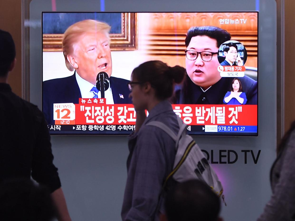 People walk past a television news screen showing North Korean leader Kim Jong Un (right) and US president Donald Trump at a railway station in Seoul (file photo): JUNG YEON-JE/AFP/Getty Images