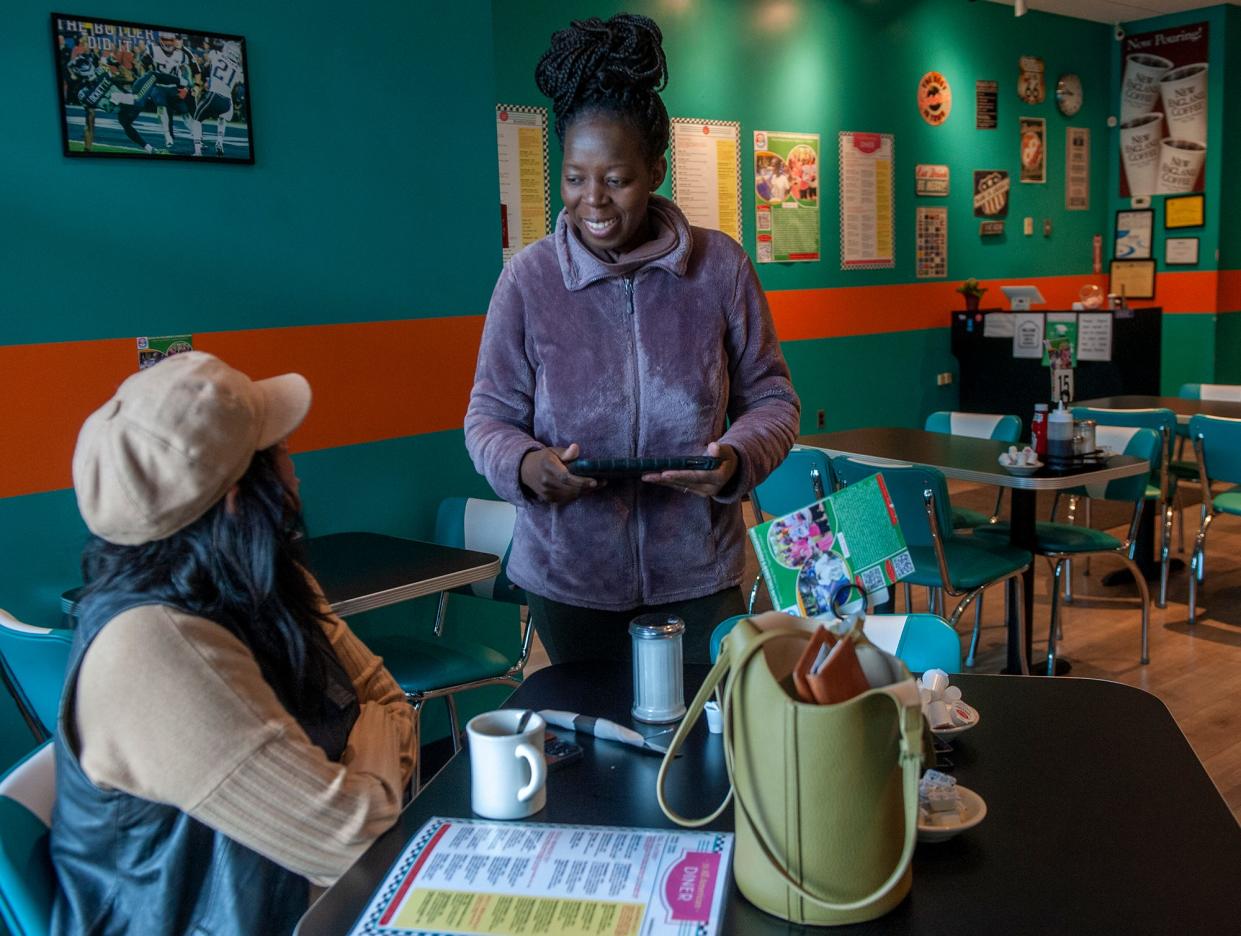 Norah Zoummar waits on a customer at her 33 All American Diner in Ashland, April 3, 2024. She donates all of her tips toward helping students in her native Uganda.