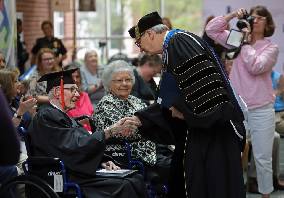 Robert Greathouse, 93, shakes hands with University of Akron President Gary Miller on Monday after receiving his associate of technical studies degree during a ceremony at UA's College of Arts and Sciences.