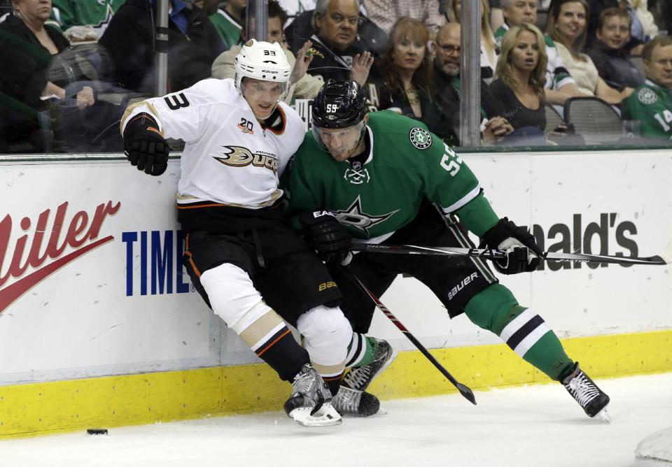 Anaheim Ducks' Jakob Silfverberg (33), of Sweden, and Dallas Stars' Sergei Gonchar (55), of Russia, compete for a loose puck behind the net in the second period of Game 4 of a first-round NHL hockey Stanley Cup playoff series, Wednesday, April 23, 2014, in Dallas. (AP Photo/Tony Gutierrez)