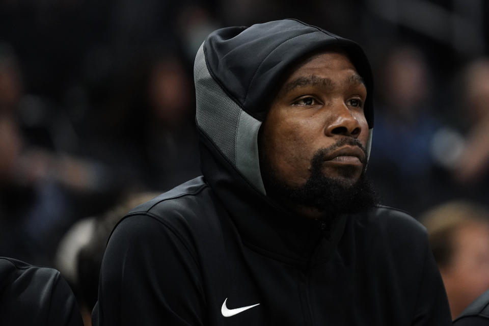 Brooklyn Nets' Kevin Durant watches from the bench during the first half of an NBA preseason basketball game against the Milwaukee Bucks Wednesday, Oct. 12, 2022, in Milwaukee. (AP Photo/Aaron Gash)