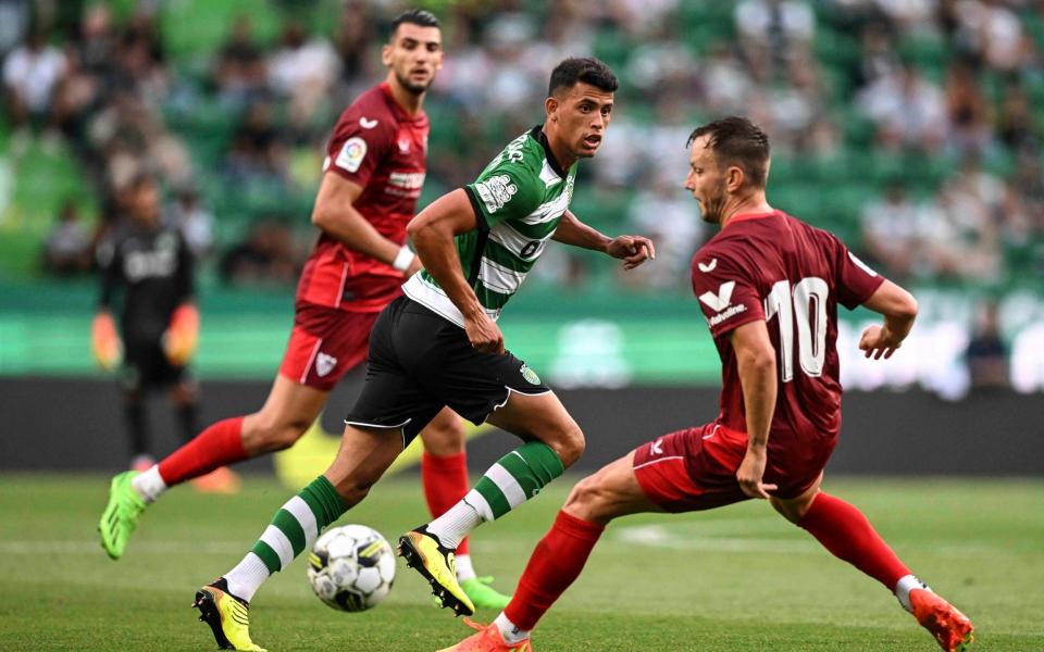 Sporting Lisbon's Brazilian midfielder Matheus Nunes (L) fights for the ball with Sevilla's Croatian midfielder Ivan Rakitic - AFP