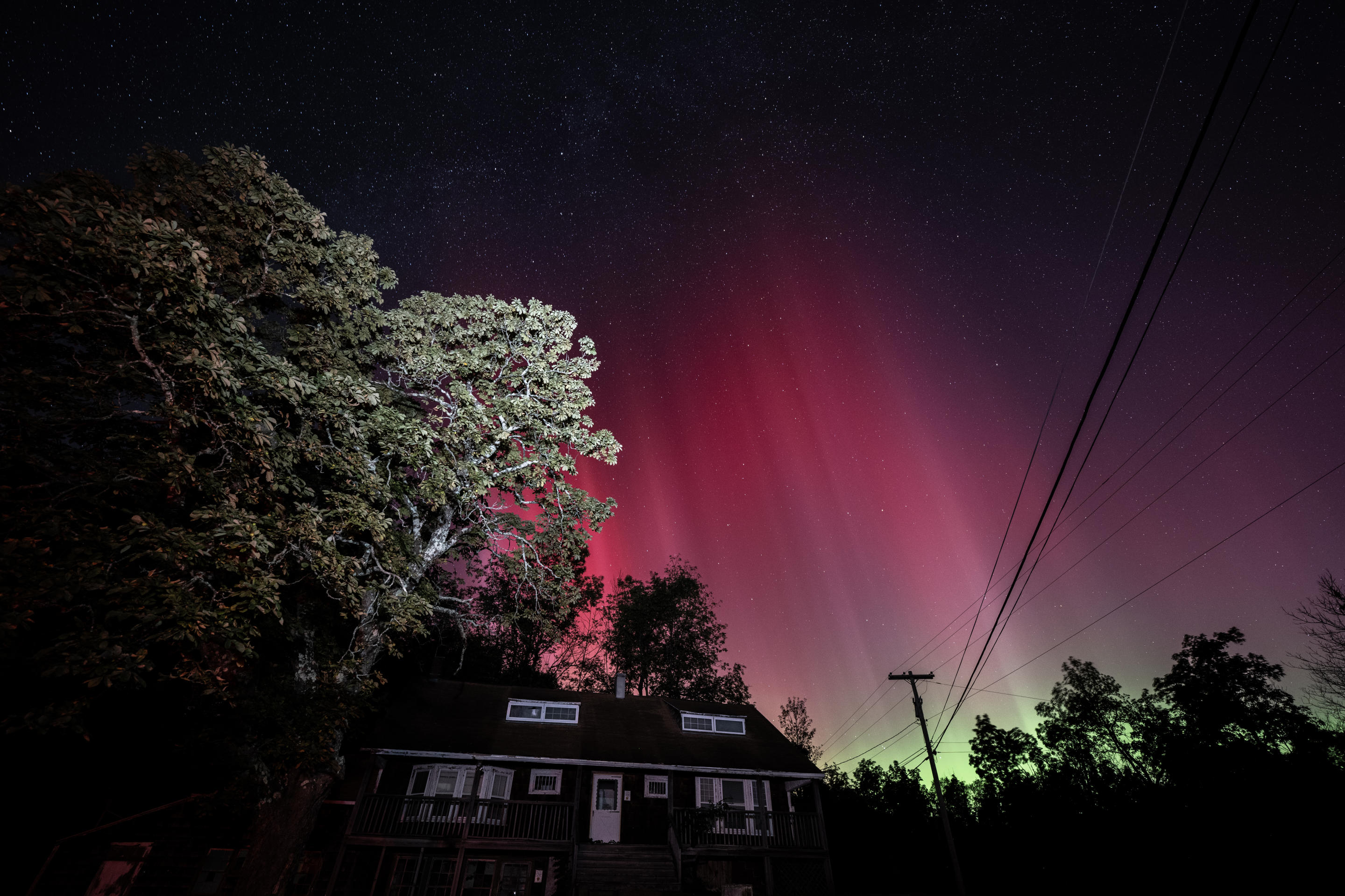 Ein seltener und farbenfroher Anblick, wenn das Nordlicht den Himmel über einem Haus in New York erleuchtet.