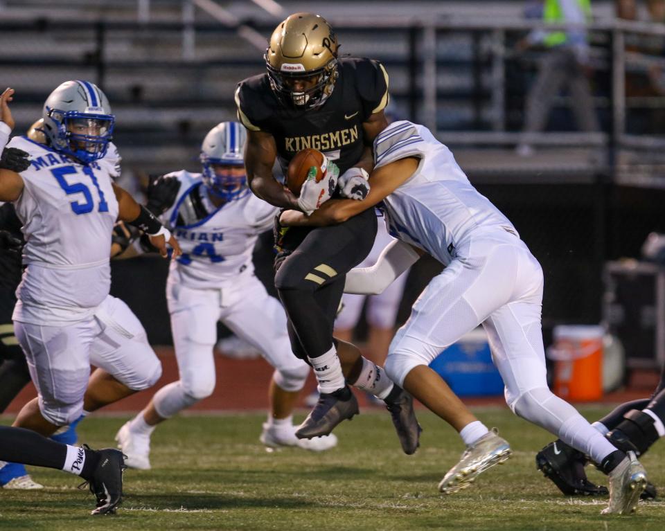 Penn running back Josiah Williams (7) tries to escape from Marian’s Kaden Middleton (7) during Friday night’s game at Penn.