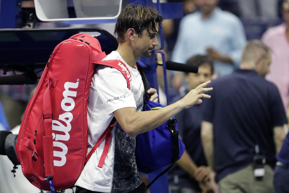 David Ferrer, left, of Spain, leaves the court after retiring from his first-round match against Rafael Nadal, also of Spain, at the U.S. Open tennis tournament, Monday, Aug. 27, 2018, in New York. (AP Photo/Julio Cortez)