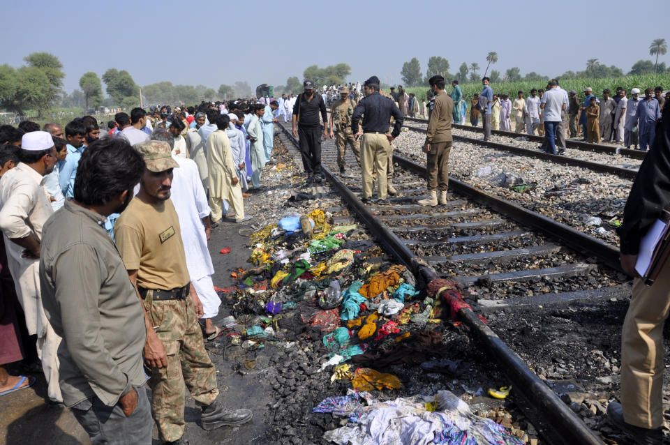 Pakistani soldiers and officials examine a train damaged by a fire in Liaquatpur, Pakistan, Thursday, Oct. 31, 2019. A massive fire engulfed three carriages of the train traveling in the country's eastern Punjab province (AP Photo/Siddique Baluch)