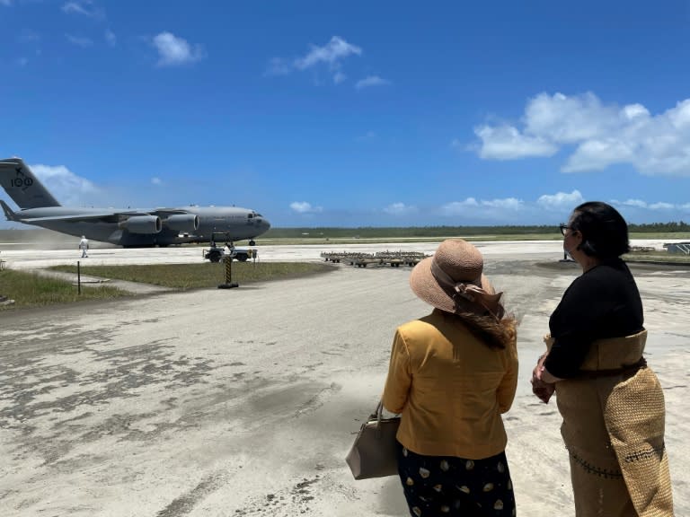 L'ambassadrice d'Australie aux îles Tonga et la ministre des Affaires étrangères des Tonga accueillent le premier avion australien atterrissant à l'aéroport, sur la piste enfin débarassée de l'épaisse couche de cendres qui la recouvrait, le 20 janvier 2021. Photo de l'armée de l'air australienne (Australian Defence Force/AFP - Handout)