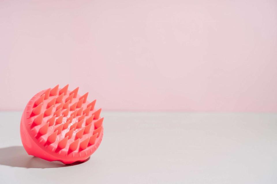 PHOTO: Pink scalp massager on green table against pink background. (STOCK PHOTO/Getty Images)