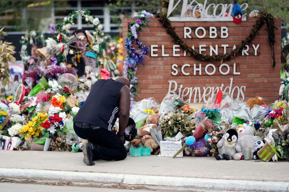 Un doliente en un monumento improvisado frente a la escuela primaria Robb en Uvalde, Texas (Derechos de autor 2022 The Associated Press. Todos los derechos reservados)