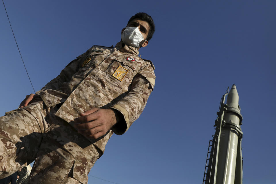 A Revolutionary Guard member walks past Qiam missile displayed in a missile capabilities exhibition by the Guard a day prior to second anniversary of Iran's missile strike on U.S. bases in Iraq in retaliation for the U.S. drone strike that killed top Iranian general Qassem Soleimani in Baghdad, at Imam Khomeini grand mosque, in Tehran, Iran, Friday, Jan. 7, 2022. Iran put three ballistic missiles on display on Friday, as talks in Vienna aimed at reviving Tehran's nuclear deal with world powers flounder. (AP Photo/Vahid Salemi)