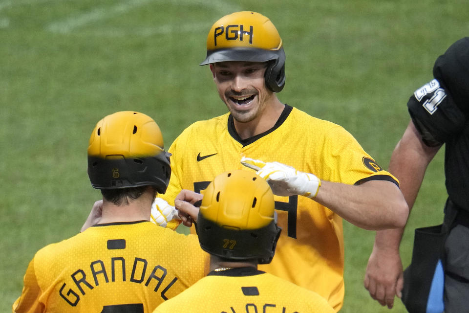 Pittsburgh Pirates' Bryan Reynolds, top, celebrates with Yasmani Grandal, left, as he crosses home plate after hitting a grand slam off New York Mets relief pitcher Jake Diekman during the seventh inning of a baseball game in Pittsburgh, Friday, July 5, 2024. (AP Photo/Gene J. Puskar)