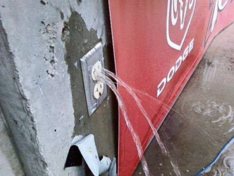 An electrical wall outlet has water spraying out of it