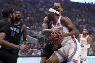 Oklahoma City Thunder guard Shai Gilgeous-Alexander (2) is fouled on a drive to the basket by Dallas Mavericks' P.J. Washington, rear, as Derrick Jones Jr., left, ad Kyrie Irving (11) help defend on the play in the first half of Game 6 of an NBA basketball second-round playoff series Saturday, May 18, 2024, in Dallas. (AP Photo/Tony Gutierrez)