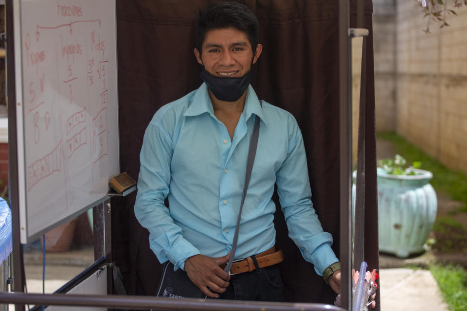 Teacher Gerardo Ixcoy poses for photo with his secondhand, adult tricycle he converted into a mobile classroom, in Santa Cruz del Quiche, Guatemala, Wednesday, July 15, 2020. The classroom-on-a-trike was born of necessity. Illiteracy in the area is about 42%. And in the entire department or province, only about 13% of homes have internet. (AP Photo/Moises Castillo)