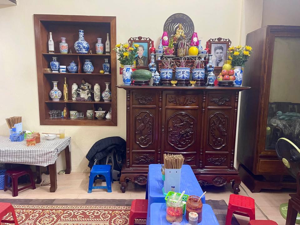 Family altar, with photos, pottery, and fruit on display at a Vietnamese restaurant in Hanoi.