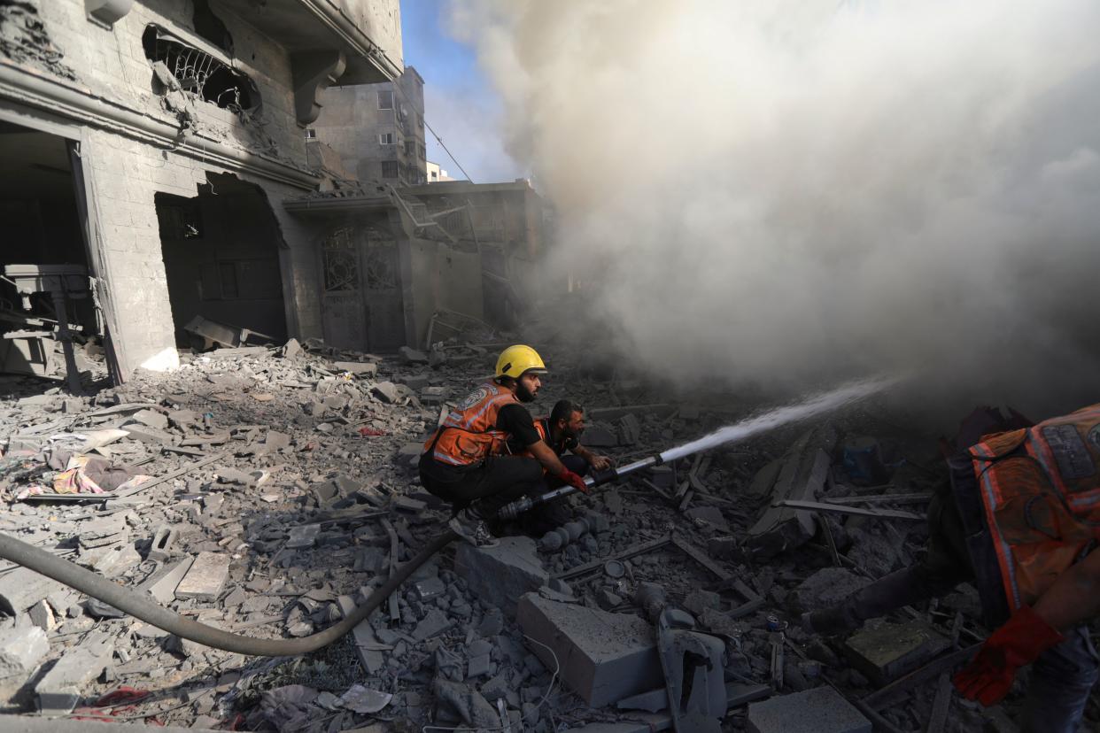 Palestinian firefighters extinguish a fire caused by an Israeli air strike in Gaza City (Abed Khaled/AP) (AP)