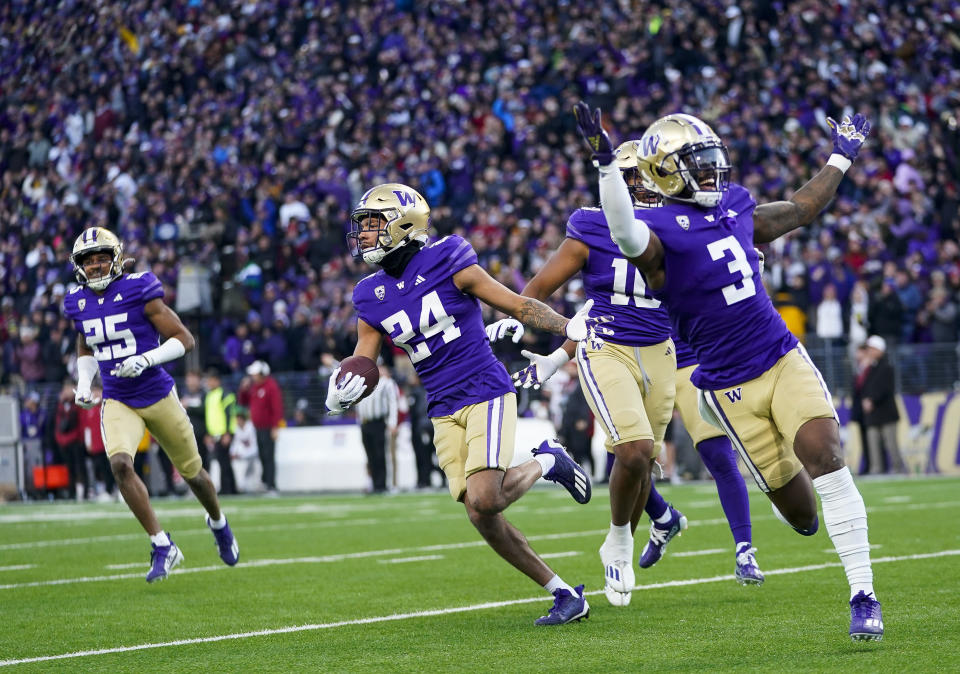 Washington safety Makell Esteen (24) runs with safety Mishael Powell (3) after making an interception against Washington State during the second half of an NCAA college football game Saturday, Nov. 25, 2023, in Seattle. (AP Photo/Lindsey Wasson)